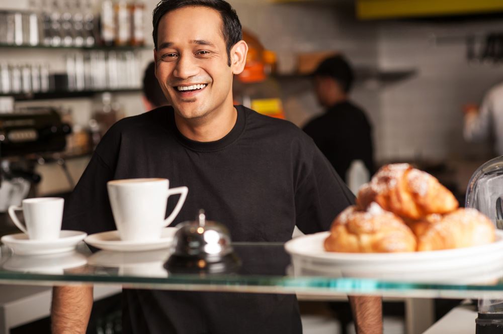 Man Smiling Behind a Food Service Counter