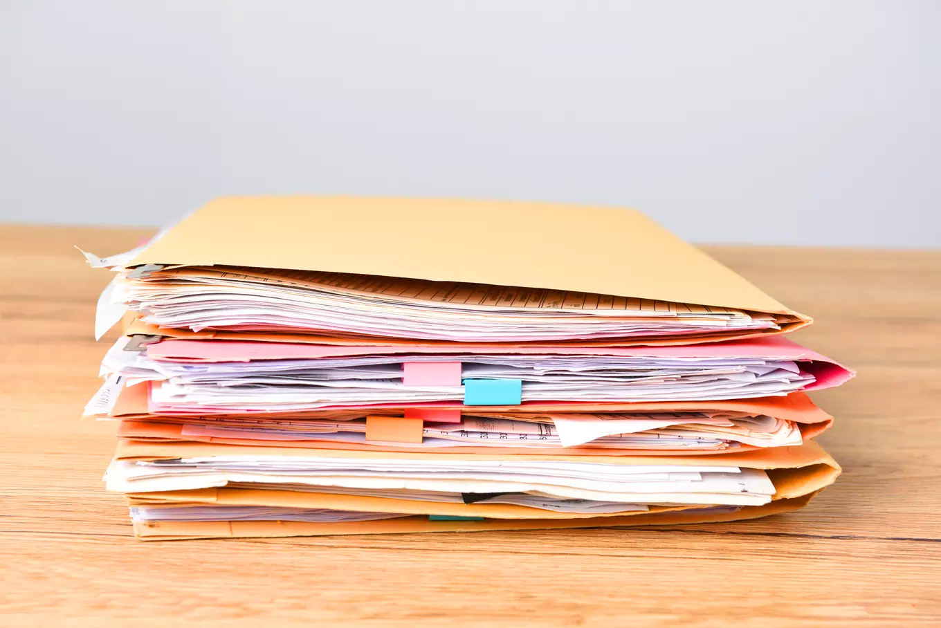 A photo of files on a wooden desk.