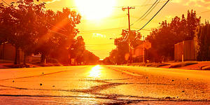 A very hot day, showing the sun beaming down the middle of a heat-stricken street.