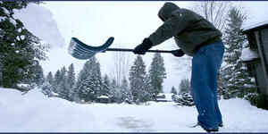 Shoveling Snow from sidewalk, person throwing snow off the shovel away from the sidewalk