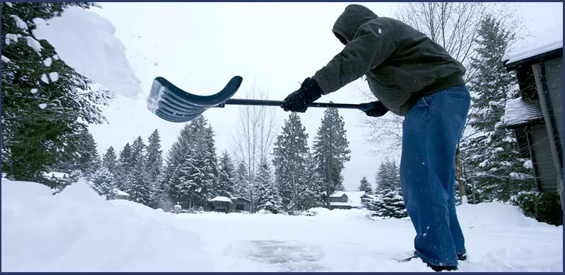 Shoveling Snow from sidewalk, person throwing snow off the shovel away from the sidewalk