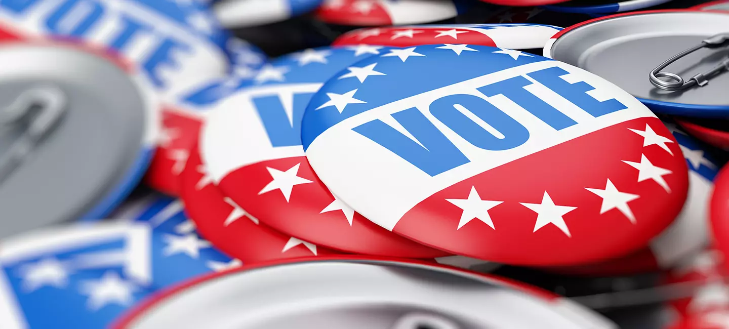 red, white, and blue pins with the word "vote"